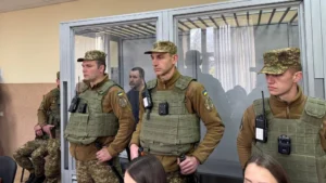 Нацгвардійці в бронежилетах біля скляної клітки із затриманим у суді