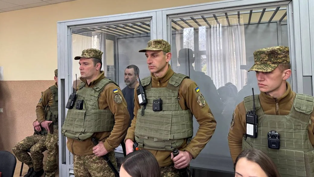 Нацгвардійці в бронежилетах біля скляної клітки із затриманим у суді