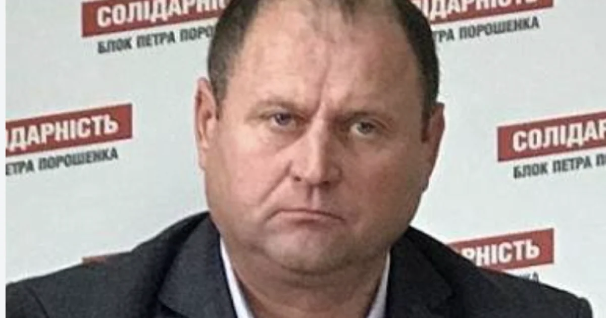 Чоловік у темному костюмі на тлі банера Солідарність Блок Петра Порошенка