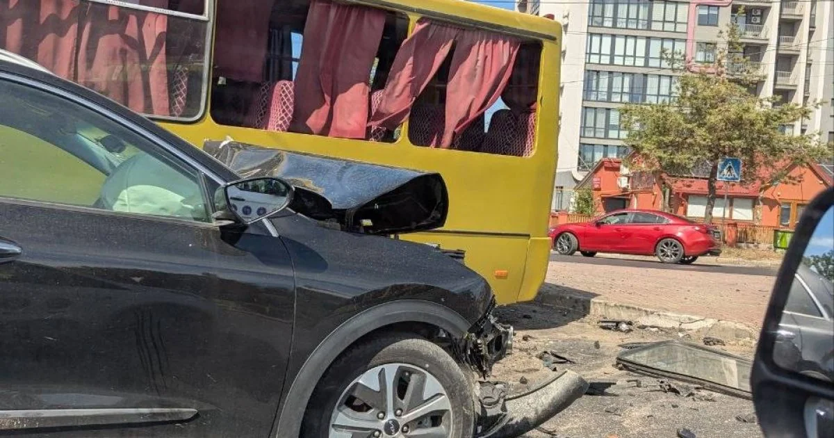 Пошкоджений чорний Kia біля жовтого автобуса з уламками на перехресті у Львові