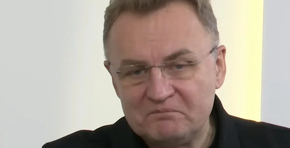 Чоловік середнього віку в окулярах і темній куртці на світлому тлі