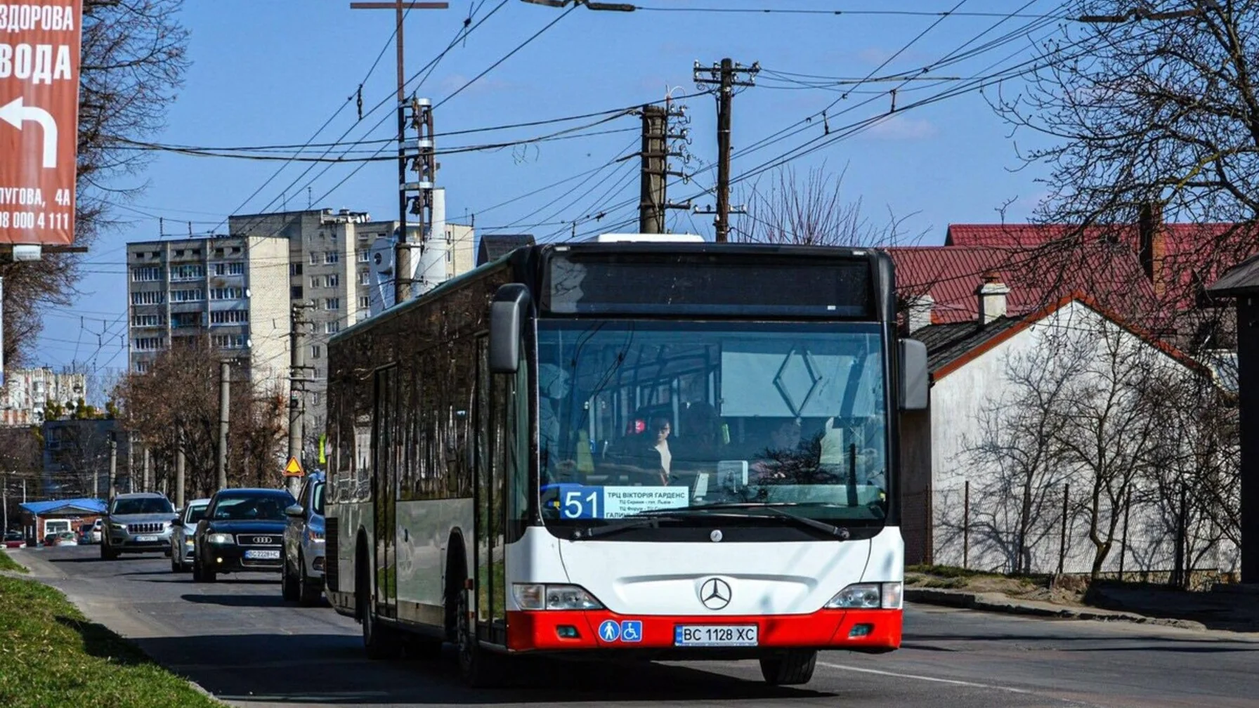 Автобус ЛеоКарт їде вулицею Львова серед житлових будинків
